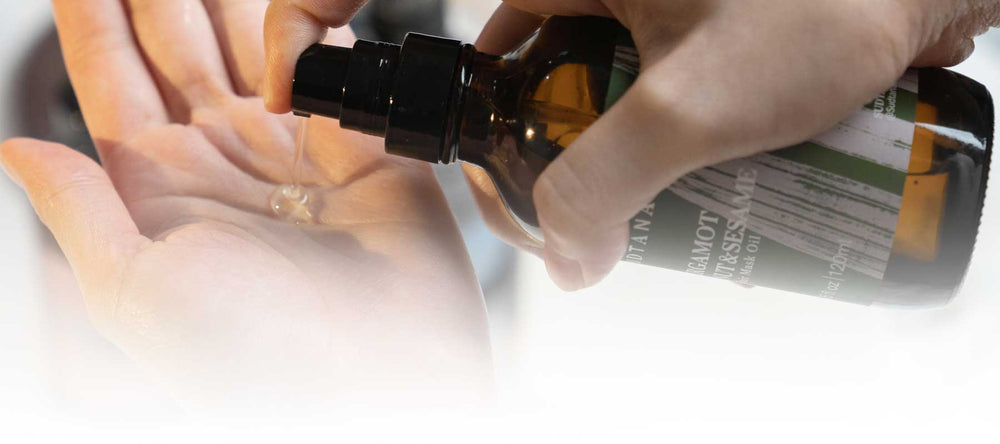Close-up of a hand dispensing SUDTANA’s Bergamot Coconut & Sesame Hair Mask Oil onto the palm, showcasing the smooth and lightweight texture of the hair mask.