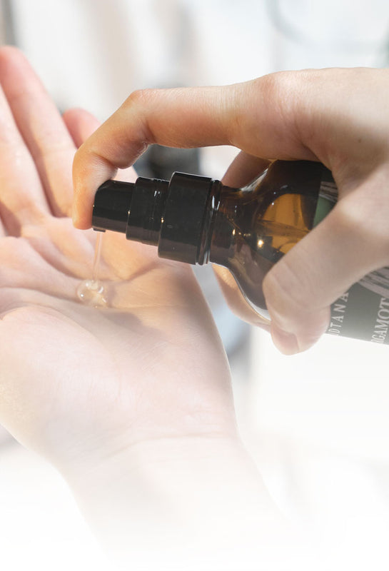 Close-up of a hand dispensing SUDTANA’s Bergamot Coconut & Sesame Hair Mask Oil onto the palm, showcasing the smooth and lightweight texture of the hair mask.
