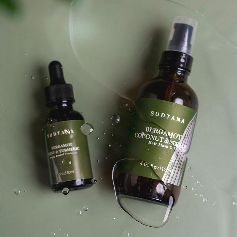 A flatlay photo of SUDTANA’s Bergamot Coconut & Sesame Hair Mask Oil and Bergamot Mint & Turmeric Scalp Revival Treatment with drops of the lightweight, fast-absorbing oils. Perfect for nourishing and revitalising hair and scalp.